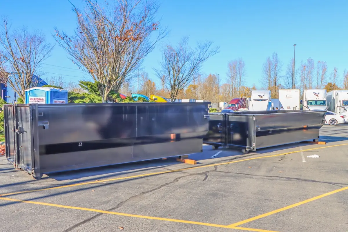 Professional dumpster rental service with roll-off container on residential driveway in Palmer